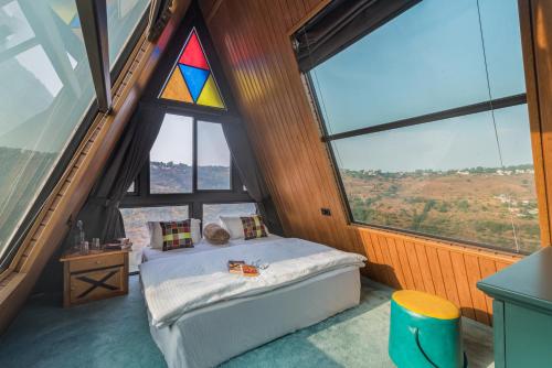 a bedroom with a bed with a stained glass window at SaffronStays A Vantage, Panchgani in Panchgani