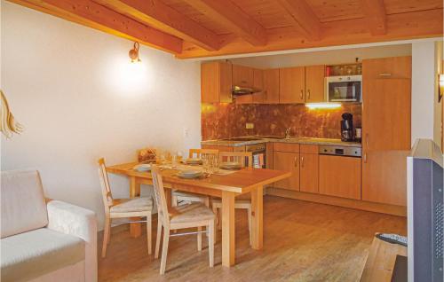 - une cuisine avec une table à manger en bois et des chaises dans l'établissement Cozy Apartment In Kappl With Wifi, à Kappl
