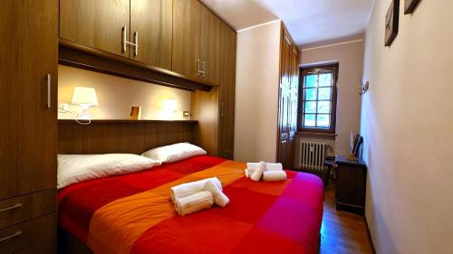a bedroom with a large bed with towels on it at Hostdomus - Edward Apartment in Cesana Torinese