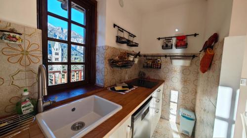 a kitchen with a sink and a window at Hostdomus - Edward Apartment in Cesana Torinese