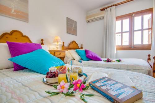 プラヤ・デ・ムロにあるIdeal Property Mallorca - Florのベッドルーム1室(ベッド2台、ドリンクと花を楽しめるテーブル付)
