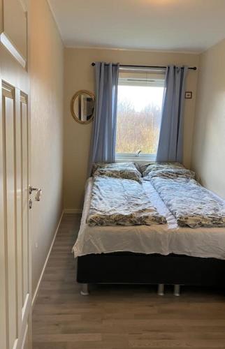 a bedroom with a bed with a window at Aurora House Dåfjord/Tromsø in Karlsøy