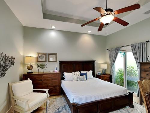 Un dormitorio con una cama y un ventilador de techo. en Mustang Isle Beach Bungalow #2, en Mustang Beach