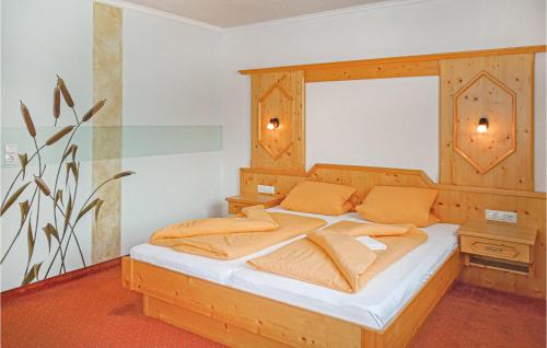 カップルにあるGorgeous Apartment In Kappl With Wifiのベッドルーム1室(大型木製ベッド1台、オレンジ色の枕付)