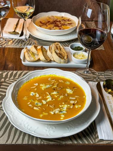 a table with a bowl of soup and glasses of wine at Blumen Hotel Boutique in Canela
