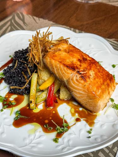 a plate of food with a piece of fish and vegetables at Blumen Hotel Boutique in Canela