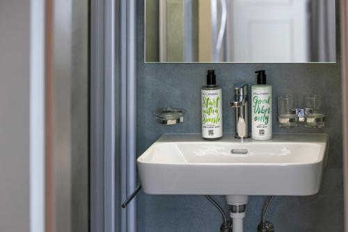 ein Bad mit einem Waschbecken und einem Spiegel in der Unterkunft Hotel Bergidyll - Riders Haven in Andermatt
