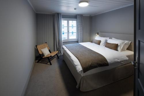 een slaapkamer met een bed, een stoel en een raam bij Hotel Bergidyll - Riders Haven in Andermatt