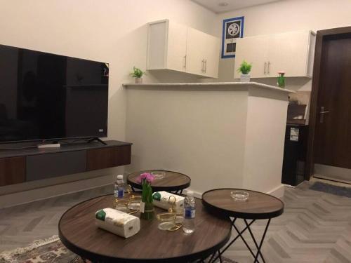ein Wohnzimmer mit 2 Tischen und einem Flachbild-TV in der Unterkunft شقه فندقيه غرفه وصاله دخول ذاتى in Riad