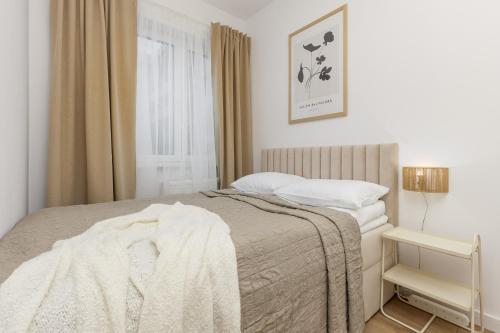 a bedroom with a bed and a window at Beautiful Studio with Garden and Parking by Renters in Warsaw