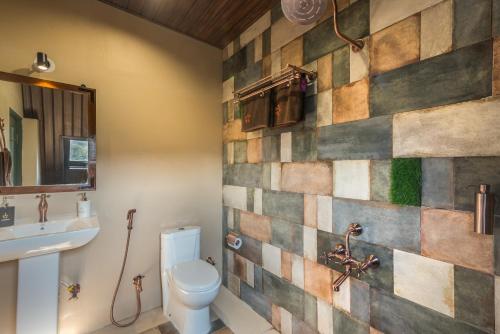a bathroom with a toilet and a sink at SaffronStays A Vantage, Panchgani - A Pyramid Shaped Unique Luxury Villa With Infinity Valley Views in Panchgani