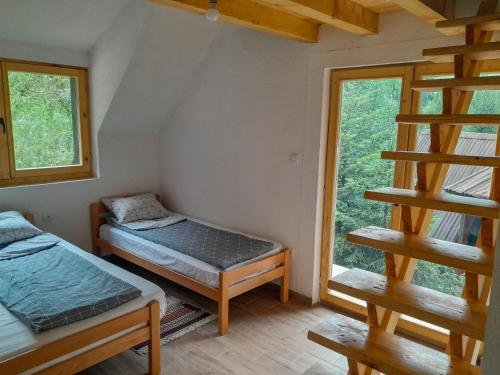 a room with two beds and a window at Rafting Camp Encijan in Foča
