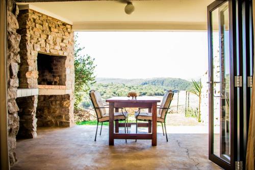 a dining room with a table and a stone fireplace at African Safari Lodge in Grahamstown