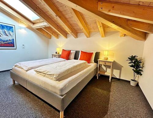 a bedroom with a large bed and a table at Maisonette: 45m2 zum Relaxen, 2 Pers./GP - ME17-B in Pontresina