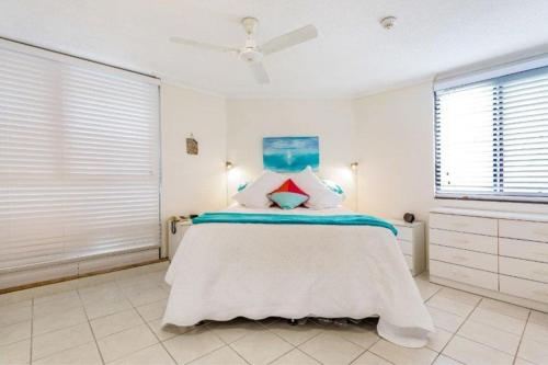 um quarto com uma cama grande e paredes brancas em Cairns Ocean View Apartment in Aquarius em Cairns