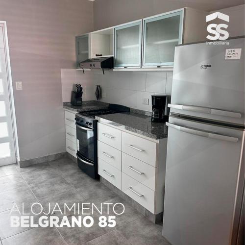 a kitchen with white cabinets and a refrigerator at BELGRANO 85 in Libertador San Martín