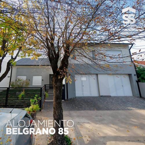 a house with white garage doors and a tree at BELGRANO 85 in Libertador San Martín