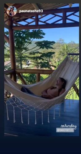 a man laying in a hammock in a hammock swing at GOLDEN TREE MINDO ECO-LODGE in Mindo
