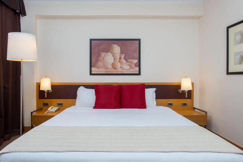 a bedroom with a large bed with red pillows at Plaza Caserta in Caserta