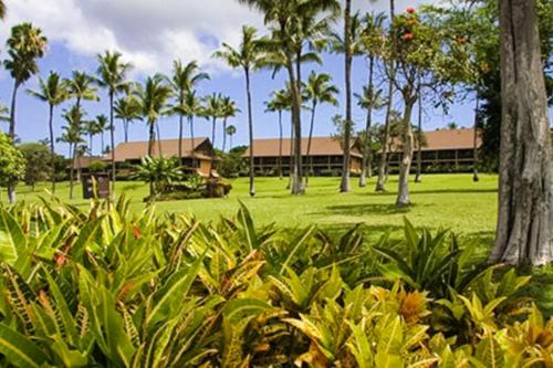 a park with palm trees and a building at Kepuhi Beach Resort in Maunaloa