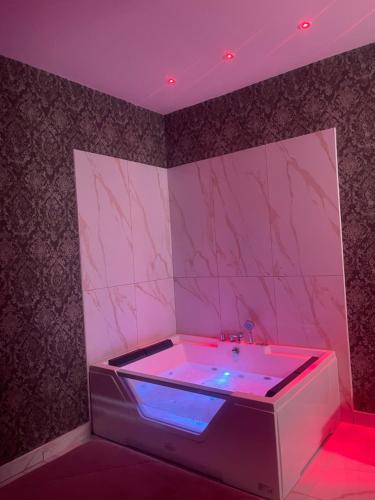 a pink bathroom with a tub with a purple lighting at Life Hotel in Casalnuovo di Napoli