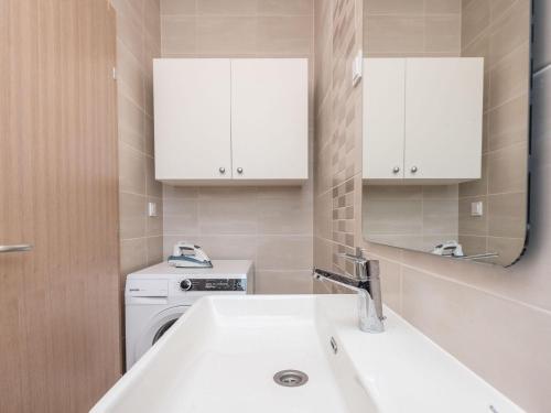 La salle de bains blanche est pourvue d'un lavabo et d'un miroir. dans l'établissement Stylish villa with private pool and terrace, à Sukošan