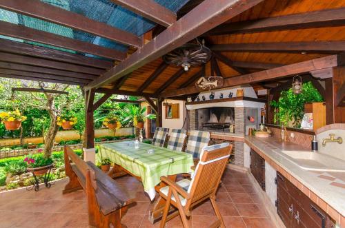 una cocina al aire libre con mesa verde y sillas en Apartments Villa Amfora, en Rovinj