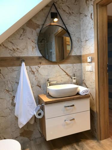 a bathroom with a sink and a mirror at Apartament Brązowy 12/1 in Starogard Gdański