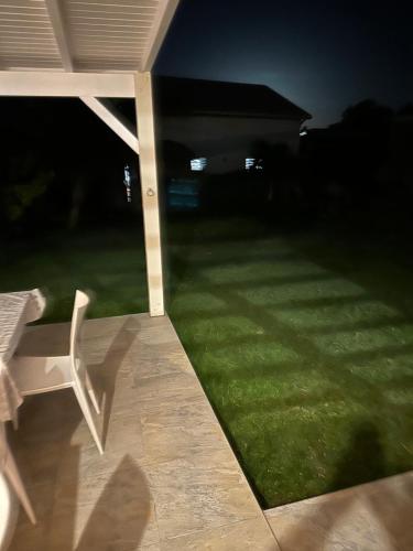 a yard at night with a chair and a lawn at La caraïbe dans la station balnéaire 3 in Saint-François