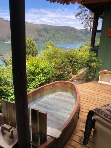 a hot tub on a deck with a view of a lake at La Rueda del Chucao in Valdivia