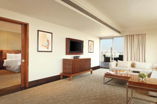 a living room with a couch and a tv at The Westin Pune Koregaon Park in Pune
