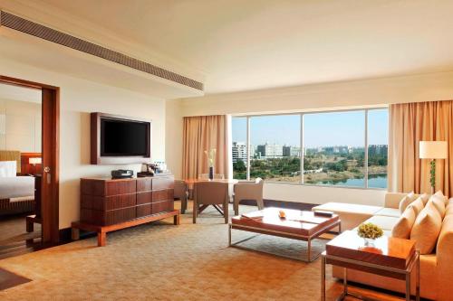 a hotel room with a living room with a large window at The Westin Pune Koregaon Park in Pune