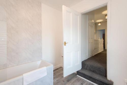 un pasillo con una puerta blanca y escaleras en Prospect Terrace en New Brancepeth
