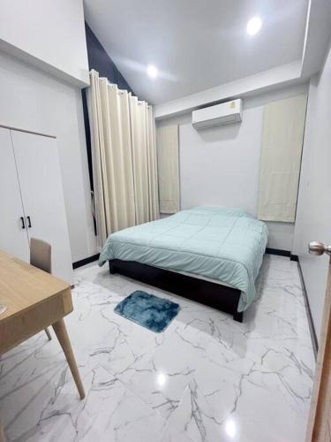 a bedroom with a bed and a marble floor at Chaya Home&Hug Phrae in Phrae