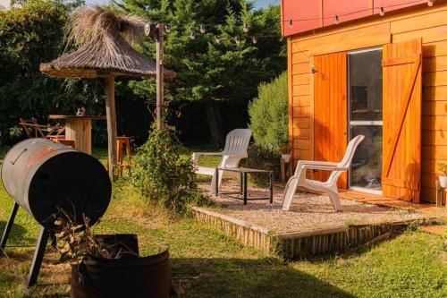 eine Terrasse mit zwei Stühlen und einem Sonnenschirm und einem Haus in der Unterkunft La Maruja de Chapa in Chapadmalal