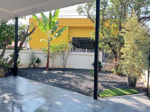 une arrière-cour avec une maison jaune et une clôture dans l'établissement Chaya Home&Hug Phrae, à Phrae
