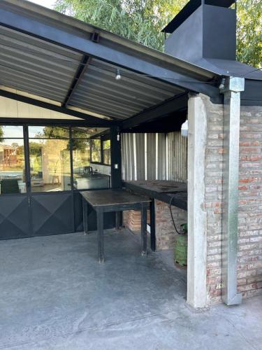 a patio with a wooden table under a roof at La Quinta de LOS ABU in Ramallo