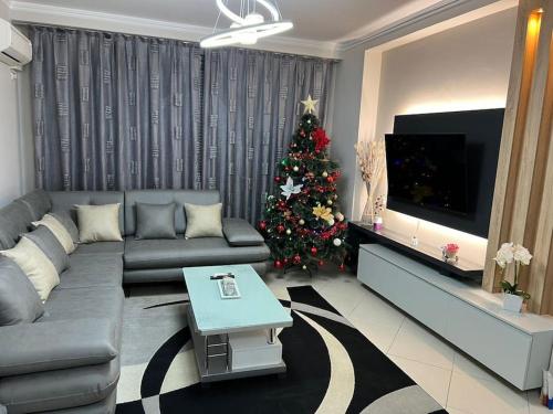 a living room with a christmas tree and a couch at Home Sweet Home in Elbasan