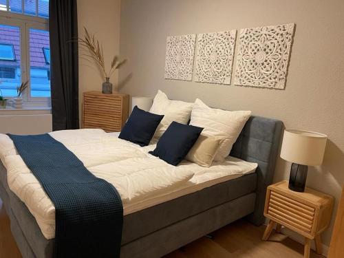 a bed with blue and white pillows in a room at OSTSEEKRABBE - Ferienwohnungen ruhig zentral in Rostock