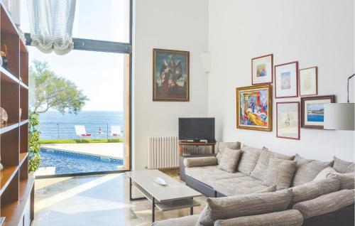 een woonkamer met een bank en een tv bij Amazing Home In Porto Colom With House Sea View in Portocolom