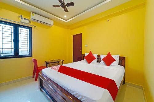 a bedroom with a large bed with yellow walls at OYO Flagship Jayam Residency in Tirupati