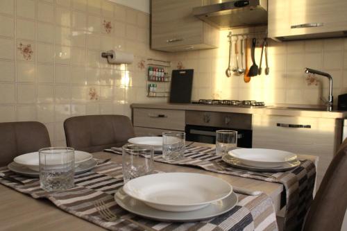 una cocina con una mesa con platos y vasos. en Appartamento del Sol, Bilocale, en Varese