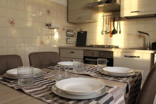 a kitchen with a table with plates and glasses at Appartamento del Sol, Free private parking, Free Wi-Fi in Varese