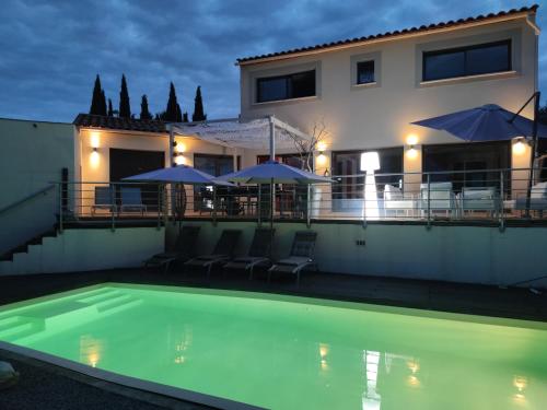 une maison avec une piscine avec chaises et parasols dans l'établissement Villa de standing, plages a 25 min, golf a 5 min, à Juvignac