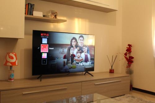 TV de pantalla plana en la parte superior de un centro de entretenimiento en Appartamento del Sol, Bilocale, en Varese