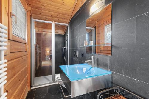 uma casa de banho com um lavatório azul e um chuveiro em Calin - 8 pers - sauna - tres ensoleille em Nendaz
