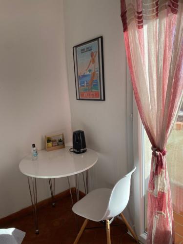 un tavolo e una sedia in una stanza con finestra di Chambre au cœur des vignes a Pertuis