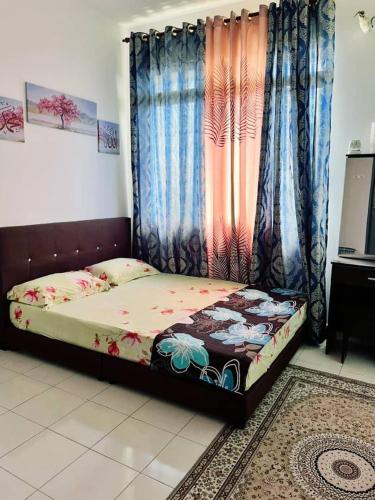 a bedroom with a bed and curtains and a television at Putrajaya Homestay (Zurinn 2) in Putrajaya