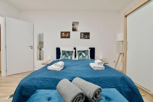 a large blue bed with towels on top of it at Standard Apartment by Hi5-Horváth Mihály square in Budapest