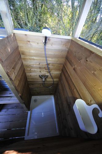 a shower in a tiny house with a toilet at Monte dos Vagabundos - Animal Sanctuary - Caravan nest in São Teotónio